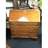A Georgian mahogany bureau fitted four graduated drawers, brass drop handles, pull out slides,