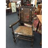 A Carolean design beech framed elbow chair with carved Crown back, barley twist supports and fronts,