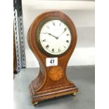 An early 20th century inlaid mahogany balloon cased mantle clock resting on four brass ball feet,