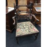 An early Chippendale style mahogany elbow chair with pierced lattice back, acorn knobs, fluted legs,