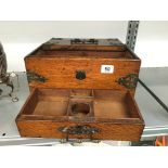 An early 20th century oak cased stationery/cigarette box with brass mounts and sliding drawer