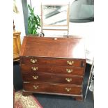 A Georgian mahogany bureau with four graduated drawers, fitted interior, resting on bracket feet.