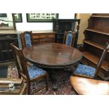 A Victorian extending oak dining table with pull-out under section resting on pedestal support,