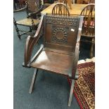 A Victorian oak Glastonbury style armchair with solid seat and wheelback carved cresting rail.