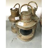 A set of three brass ship's lamps.