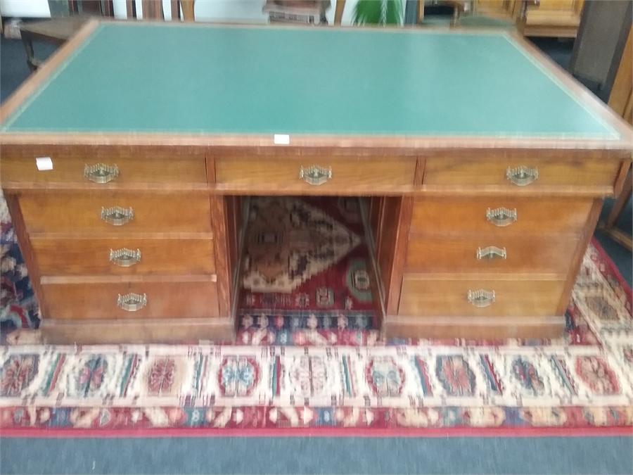 A large oak partners twin pedestal desk with doors to back and drawers to front with fitted with