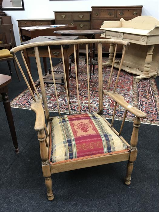 An Arts and Crafts style armchair with upholstered seat.