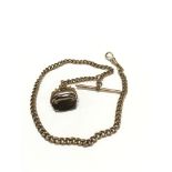 A 9ct gold brown stone spinning fob on a rolled gold albert chain