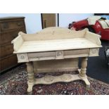 A 19th century pine washstand with two freize drawers to front resting on pillar supports.