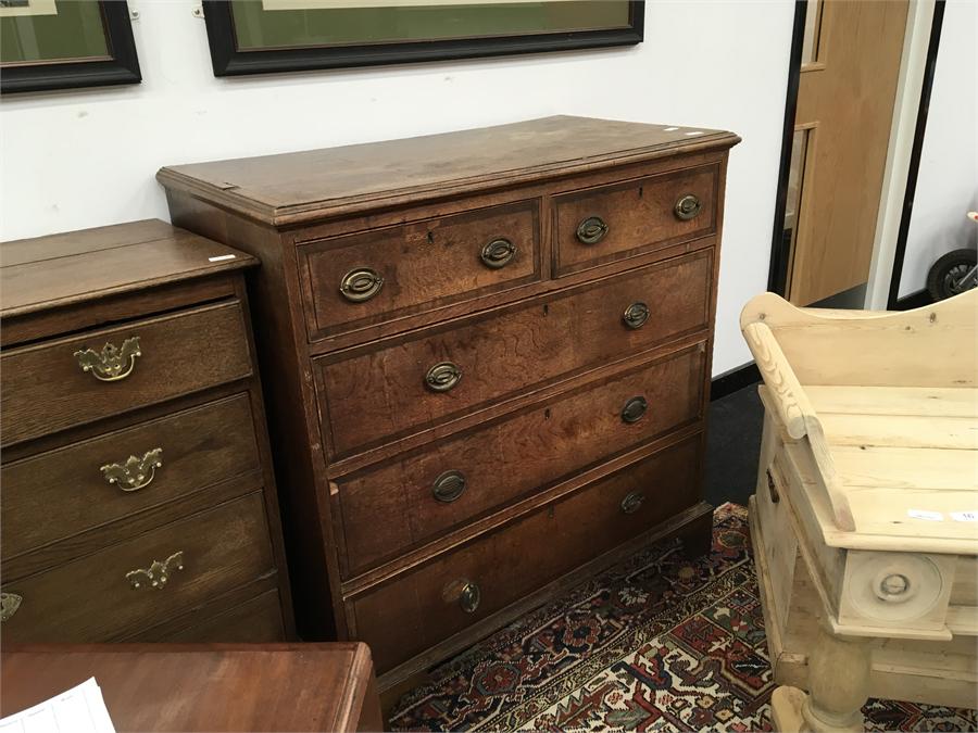 A 19th century oak chest of drawers with two small drawers over three with brass drop handles and