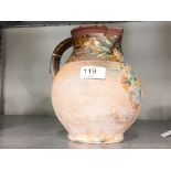 A Verwood pottery terracotta single handled jug with hand painted floral decoration (19.5 cm