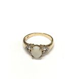 A 9ct gold ring set with and Opal and diamond set shoulders. Size L.