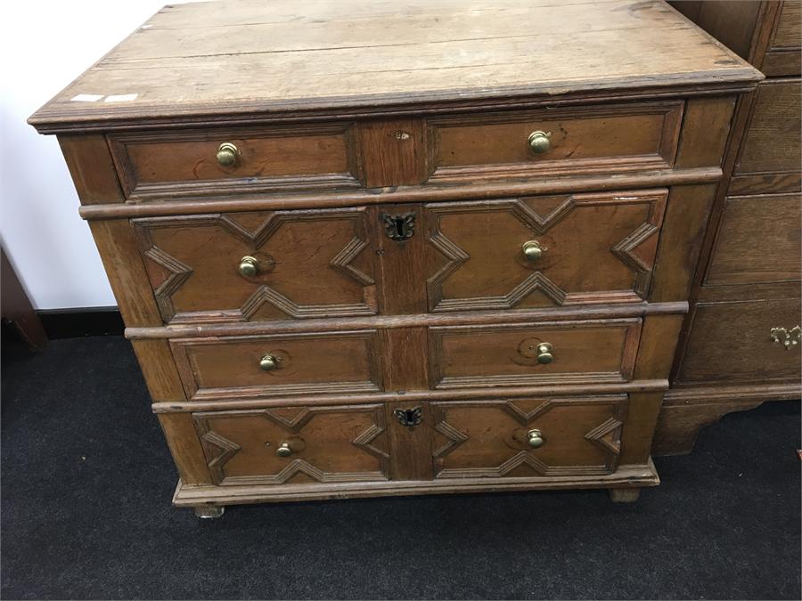 An 18th century oak chest of drawers with geometric design to drawer fronts and replacement