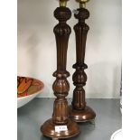 A pair of 19th century style wooden candlesticks with brass plated tops resting on three paw feet.