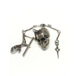 A reproduction silver watchchain with skulls and a hand.