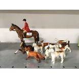 A Beswick china glazed model of a red coated huntsman with eight dogs and a fox together with a