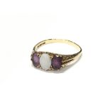 An Amethyst and Opal three stone 9ct yellow gold ring. Size S.