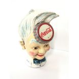 A reproduction cast iron Coca Cola money box decorated as a young boy.