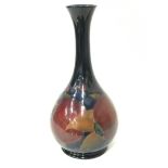 A William Moorcroft baluster shaped long neck vase decorated in the pomegranate pattern, signed