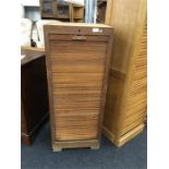 A mid 20th century oak tambour fronted cabinet with fitted interior.