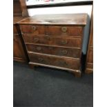 A Georgian walnut chest of drawers with feather banding resting on bracket feet.