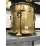 A brass Arts & Crafts coal bucket with four tapering supports with ring handles.