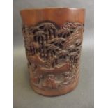 A Chinese carved bamboo brush pot decorated with figures in a garden, 6½" x 5½"