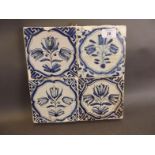 A set of four antique Delft blue and white tiles decorated with tulips, 10" square