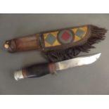 A vintage hunting knife with sectional handle in First Nation style and leather sheath, 9½" long