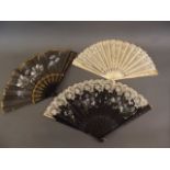 A Victorian bone and lace fan with painted floral decoration, an ebonised and lace fan, and