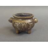 A small Chinese bronze censer with twin kylin handles and bat decoration, on tripod feet, seal