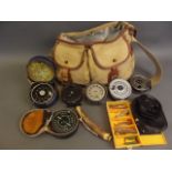 A fishing bag containing seven various reels, a loaded horn priest, spinners, line etc