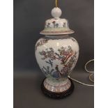 A large Oriental porcelain baluster vase shaped lamp base, on a carved wood stand, 24" high