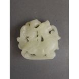 A Chinese white jade pendant carved in the form of a phoenix on a dragon's back, 2" long