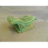 A Chinese green crackle glazed pottery pillow with raised lotus flower decoration, 9½" x 4½"