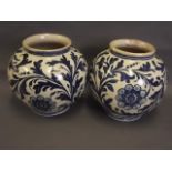 A pair of C19th Continental Majolica blue and white bulbous jars with hand painted floral and leaf