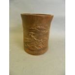 A Chinese bamboo brush pot with carved decoration of a fisherman by a lake with distant mountains,