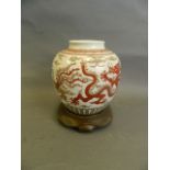 A Chinese red and green enamelled ginger jar with dragon and phoenix decoration, on a frilled bronze