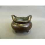 A Chinese bronze censer with twin phoenix eye handles, on tripod supports, seal mark to base, 4"