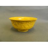 A Chinese yellow ground porcelain rice bowl with raised dragon decoration, seal mark to base, 6"