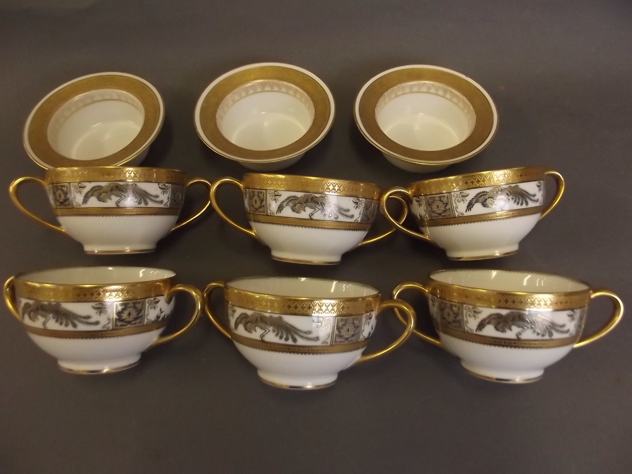 A set of 6 Limoges porcelain twin handled cups decorated in black and gilt with exotic birds