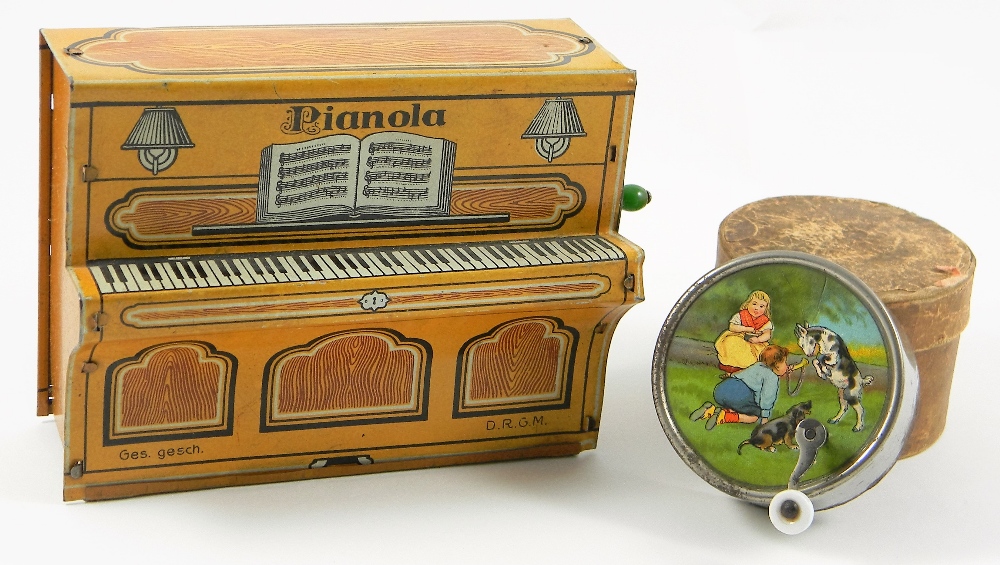 Tin-plate Pianola music box, German 1920’s, the printed tin with music book, lamps and key board,