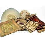 Dolls house rugs and material scraps, including four red and blue wool rugs, another in silk with