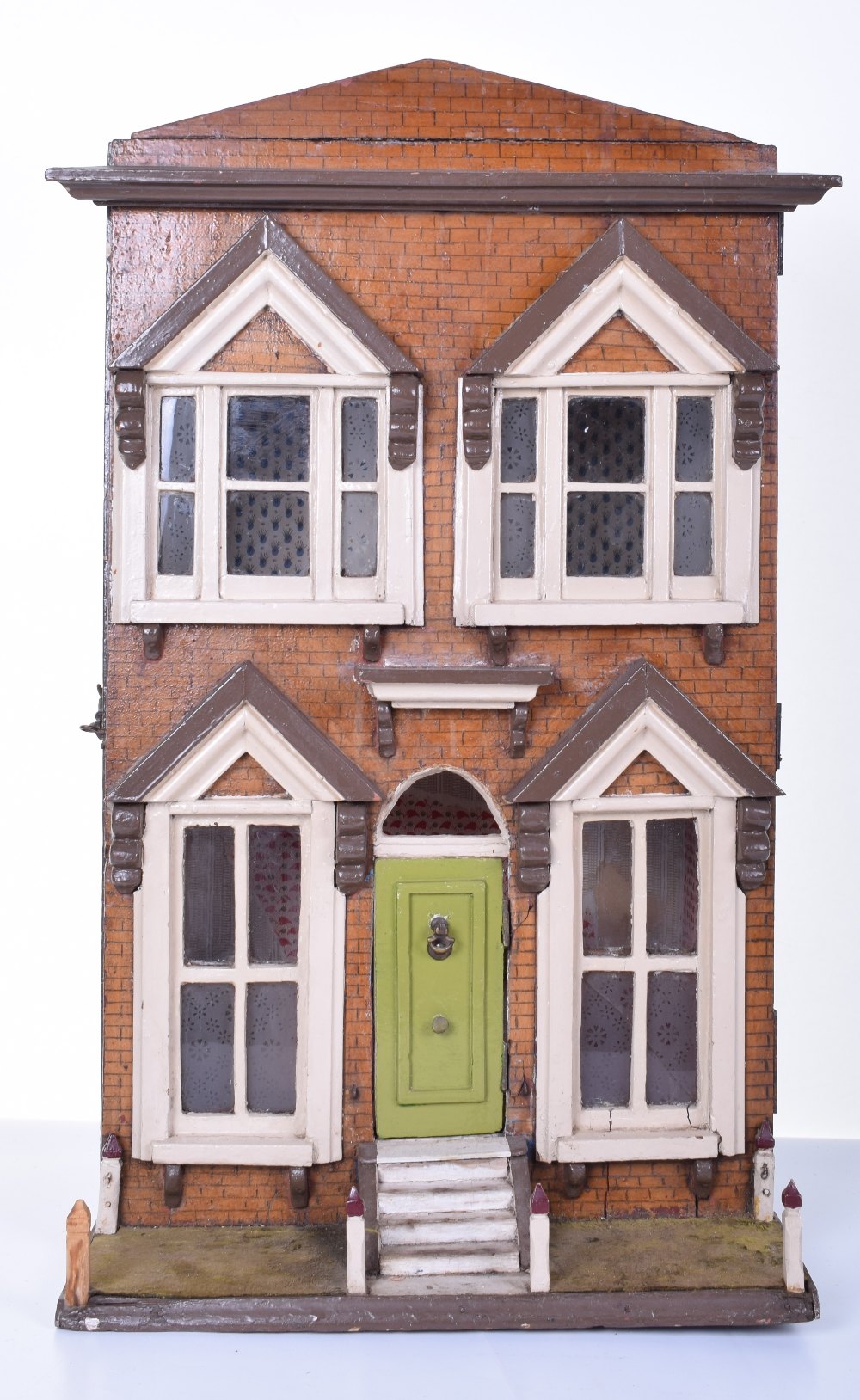 A painted wooden box back English Dolls house, circa 1890, painted red brick façade, small garden