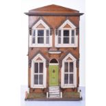 A painted wooden box back English Dolls house, circa 1890, painted red brick façade, small garden