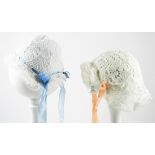 Four Babies Bonnets, circa 1910, each with decorative lace and edged with lace frills, flower