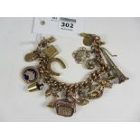Victorian rose gold curb chain bracelet stamped 9c and with various charms,