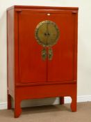Chinese red lacquered moon cabinet enclosed by two doors enclosing shelves and two drawers,