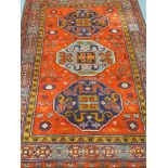 Persian rug red ground pattern border, field decorated with three guls of abstract design,