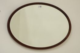 Edwardian inlaid mahogany oval mirror fitted with bevelled glass,